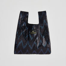 Black sequin bag with a brand label on a light gray background